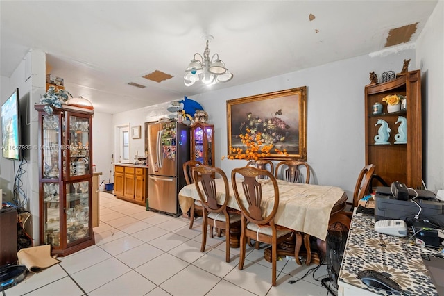 dining area featuring light tile patterned floors and an inviting chandelier