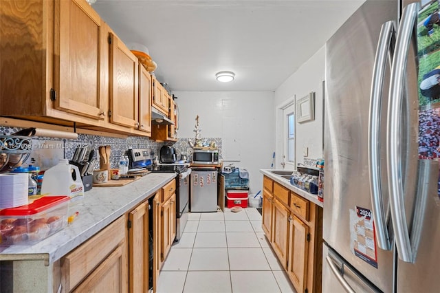 kitchen with appliances with stainless steel finishes, light tile patterned flooring, and tasteful backsplash