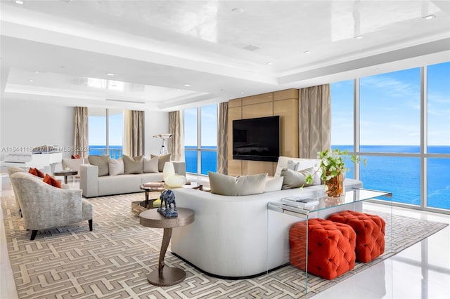 living room featuring a tray ceiling and expansive windows