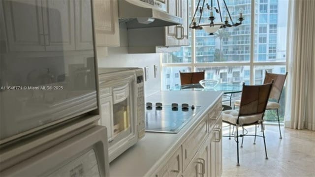 kitchen featuring electric cooktop and a chandelier