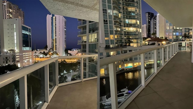 balcony at night featuring a water view