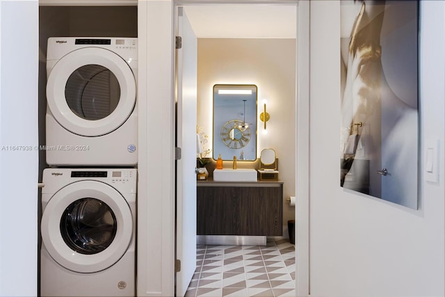 washroom featuring stacked washer / drying machine, sink, and light tile patterned floors