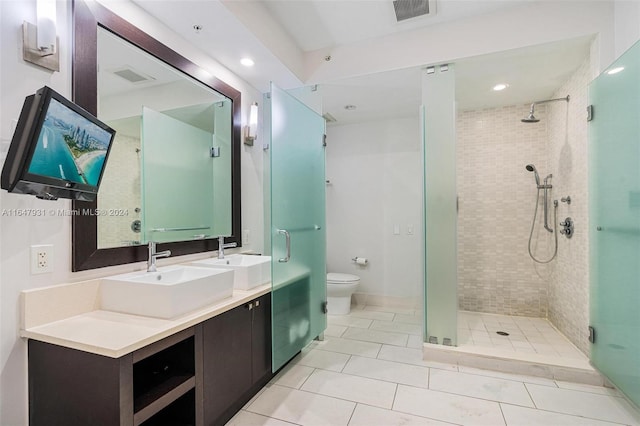 bathroom with tile patterned flooring, toilet, vanity, and walk in shower