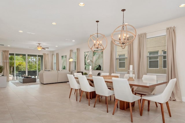 dining space featuring light tile patterned floors and ceiling fan with notable chandelier