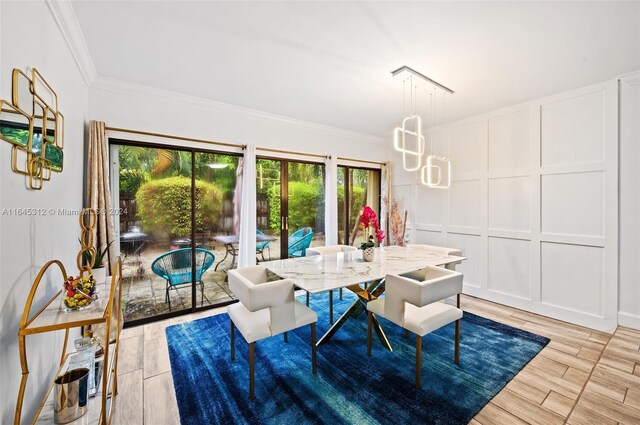 dining space with light hardwood / wood-style flooring and crown molding