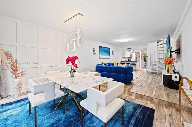 dining space with light hardwood / wood-style flooring and crown molding