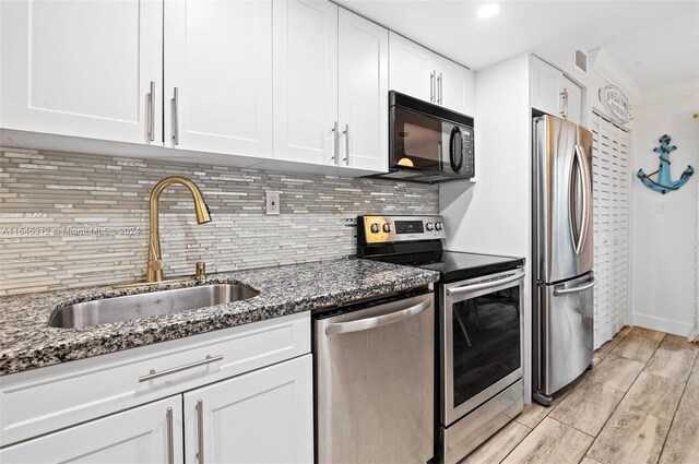 kitchen with sink, stainless steel appliances, light hardwood / wood-style floors, and white cabinetry