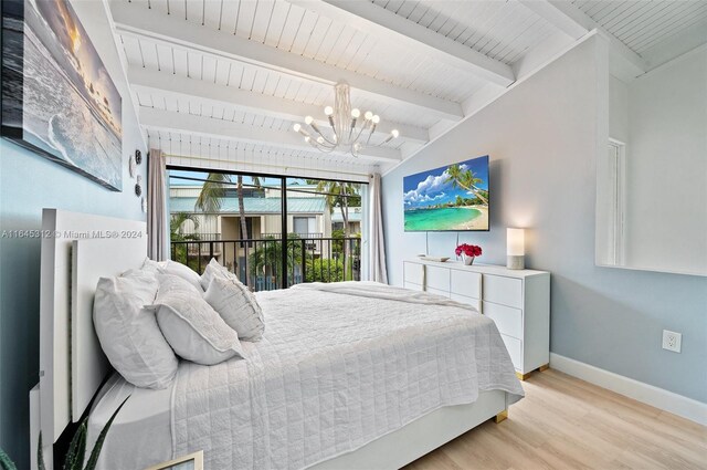 bedroom featuring beamed ceiling, light hardwood / wood-style flooring, and a chandelier