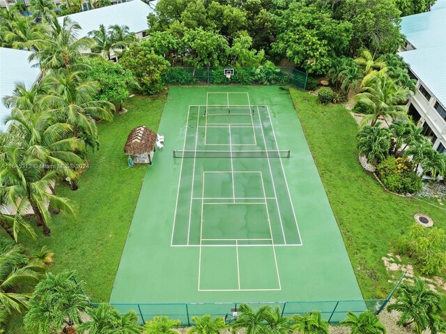 view of tennis court featuring a yard