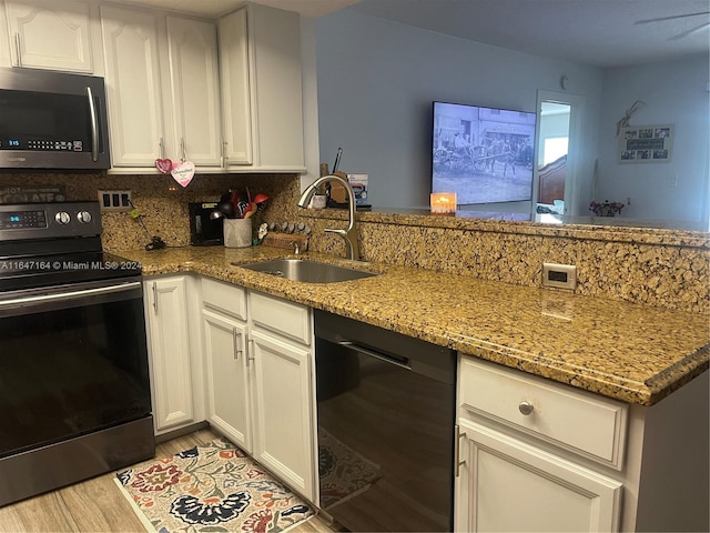 kitchen with light stone countertops, sink, white cabinets, and stainless steel appliances