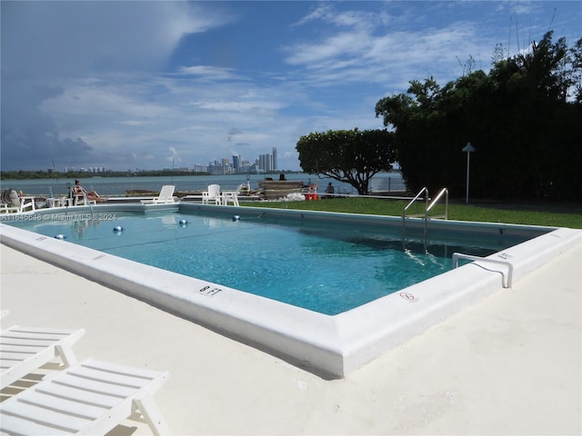 community pool with a patio area and a city view