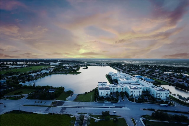 aerial view at dusk featuring a water view