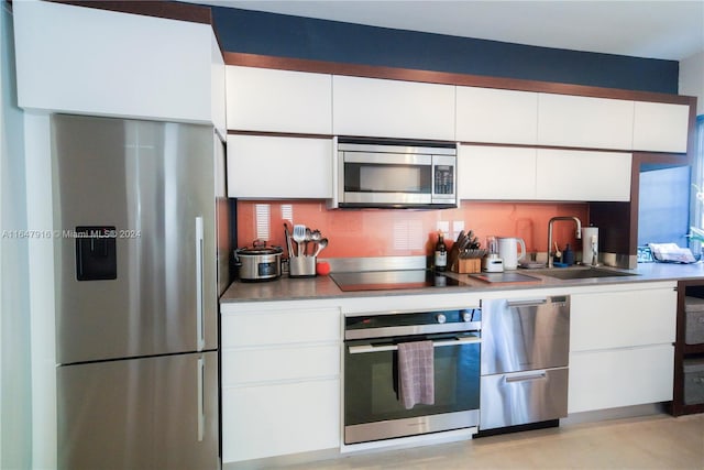 kitchen with sink, stainless steel appliances, and white cabinetry