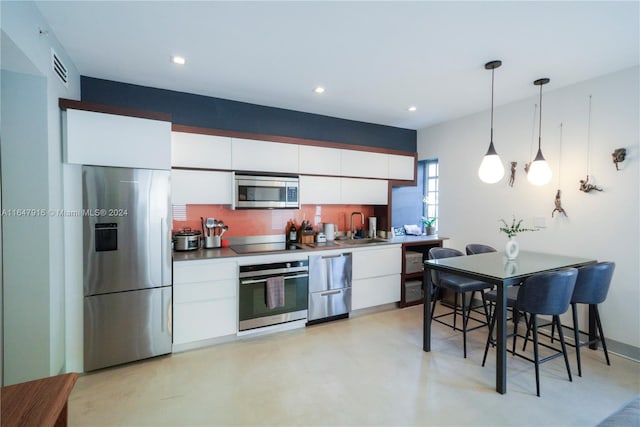 kitchen featuring a kitchen breakfast bar, pendant lighting, white cabinetry, sink, and stainless steel appliances