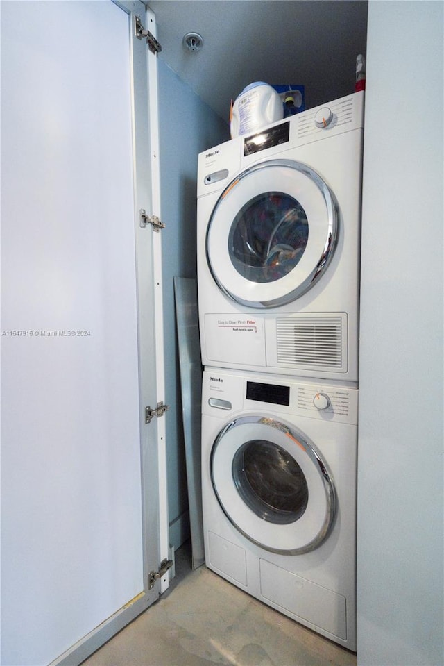 clothes washing area featuring stacked washer / drying machine