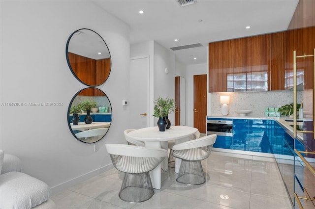 kitchen featuring recessed lighting, baseboards, decorative backsplash, brown cabinetry, and modern cabinets