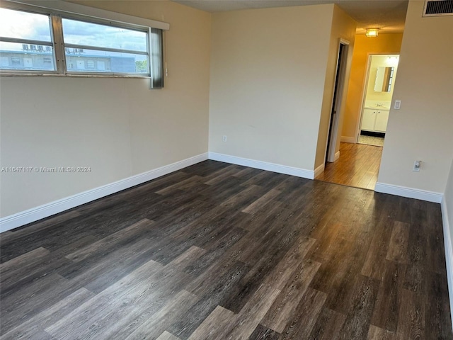 unfurnished room with dark wood-type flooring