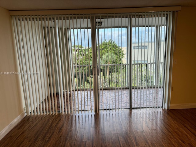 spare room featuring a healthy amount of sunlight and wood-type flooring