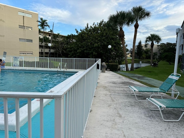 view of swimming pool with a yard