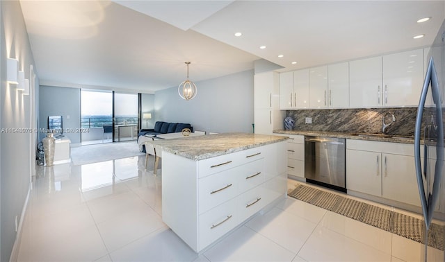 kitchen with tasteful backsplash, a kitchen island, white cabinetry, stainless steel dishwasher, and pendant lighting