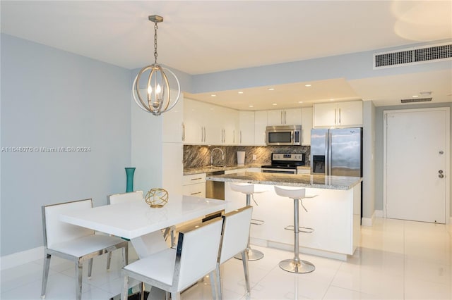 dining room featuring a notable chandelier, light tile patterned flooring, and sink