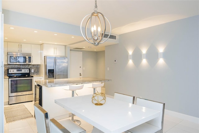 tiled dining space featuring a notable chandelier and beverage cooler