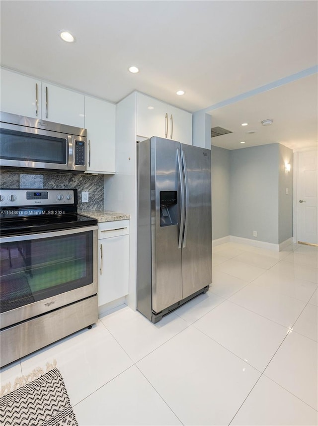 kitchen featuring white cabinetry, backsplash, appliances with stainless steel finishes, and light tile patterned flooring