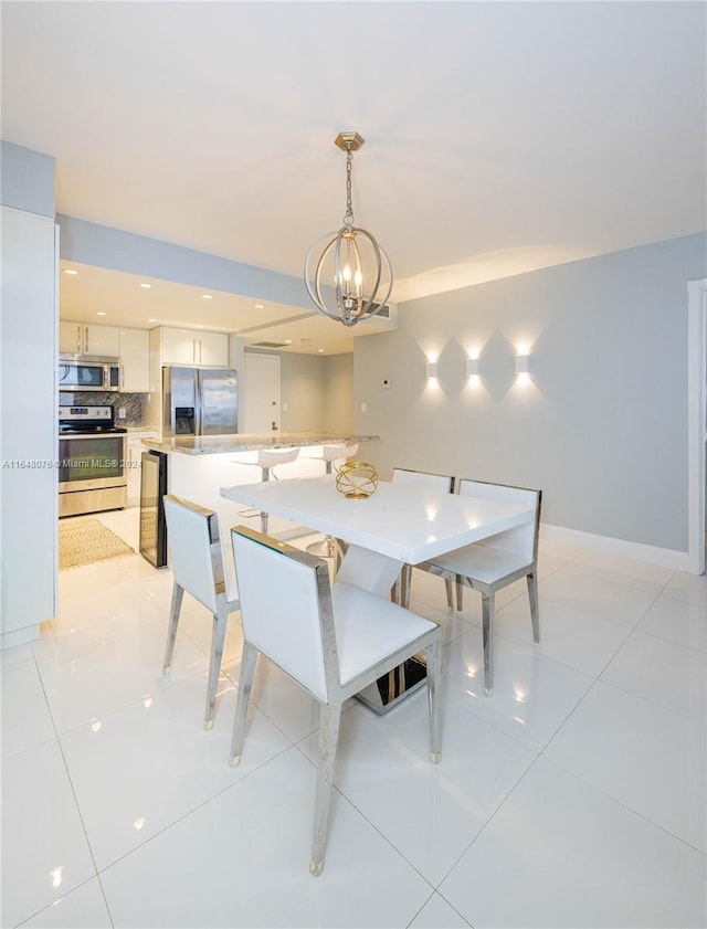 tiled dining room with a chandelier