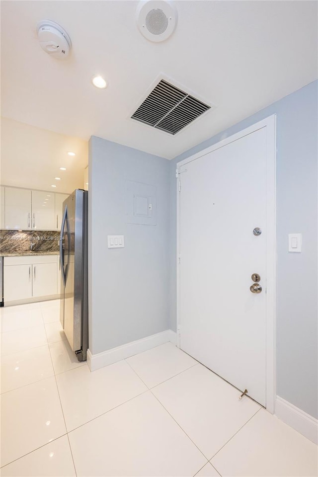 corridor with sink and light tile patterned floors