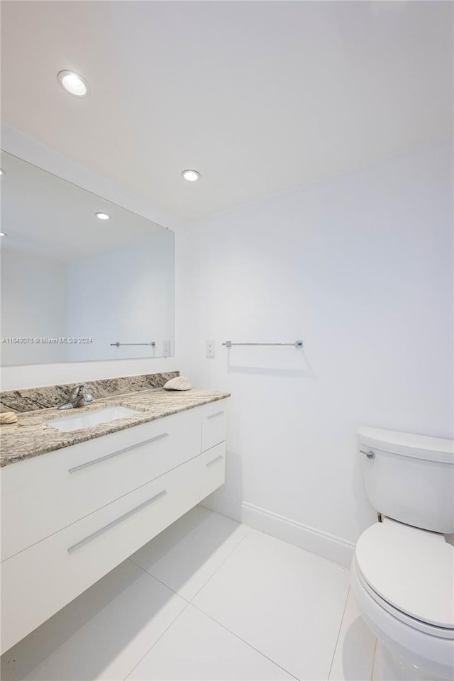 bathroom featuring toilet, vanity, and tile patterned floors