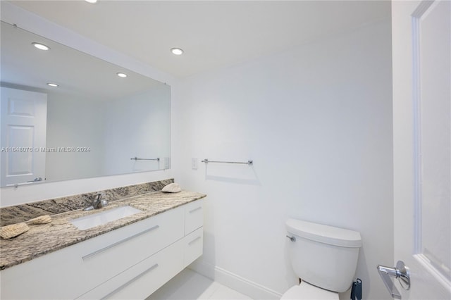 bathroom featuring toilet, vanity, and tile patterned flooring