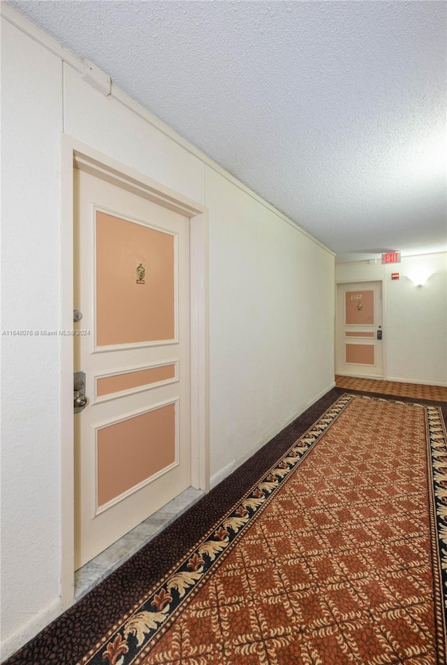 600 Three Islands Blvd Unit 1501, Hallandale Beach, FL 33009 - hallway featuring a textured ceiling and carpet flooring