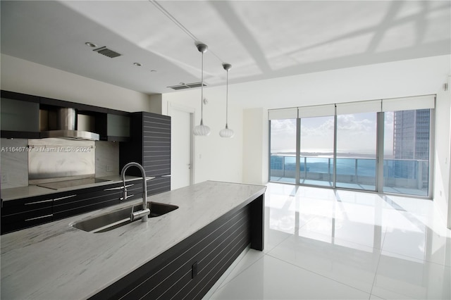 kitchen featuring light tile patterned flooring, black electric cooktop, decorative light fixtures, and sink