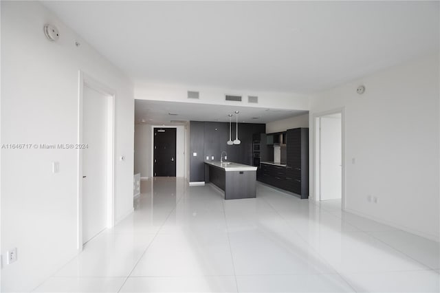 kitchen featuring a kitchen island, sink, hanging light fixtures, and light tile patterned floors