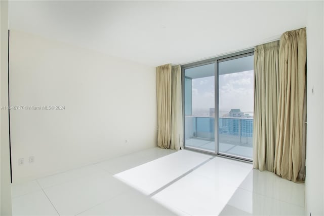 tiled spare room with floor to ceiling windows