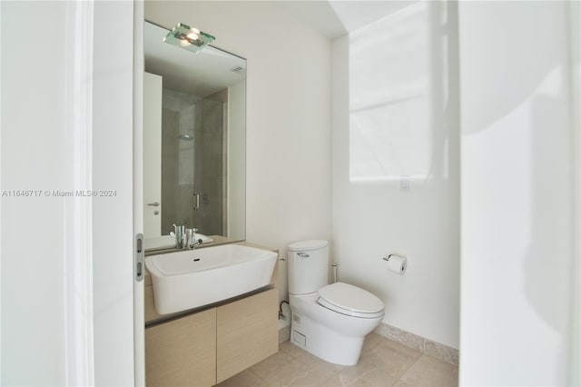 bathroom featuring vanity, a shower with shower door, toilet, and tile patterned flooring