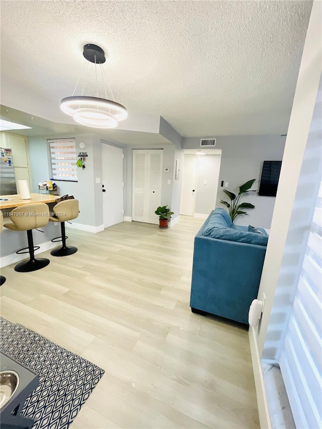 interior space with light wood-type flooring and a textured ceiling