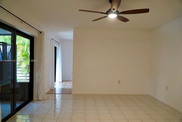 tiled spare room with ceiling fan