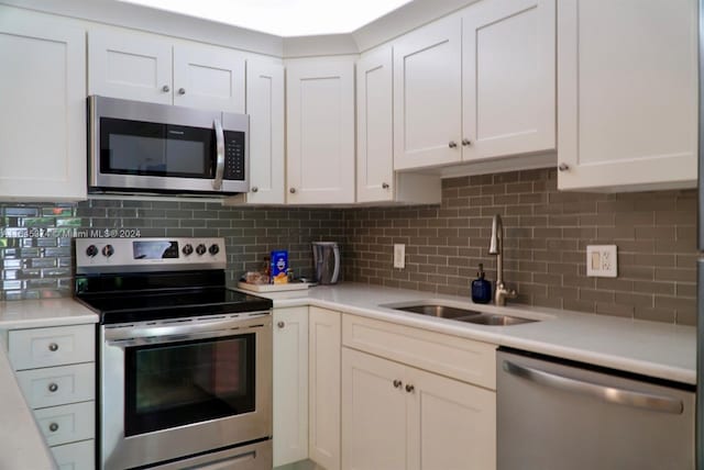 kitchen featuring white cabinetry, appliances with stainless steel finishes, sink, and backsplash