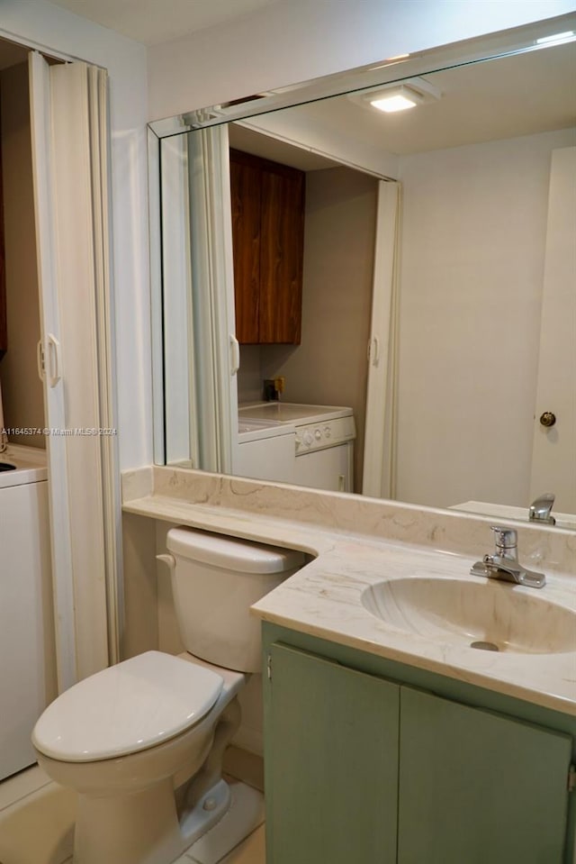 bathroom with washer / dryer, toilet, and vanity