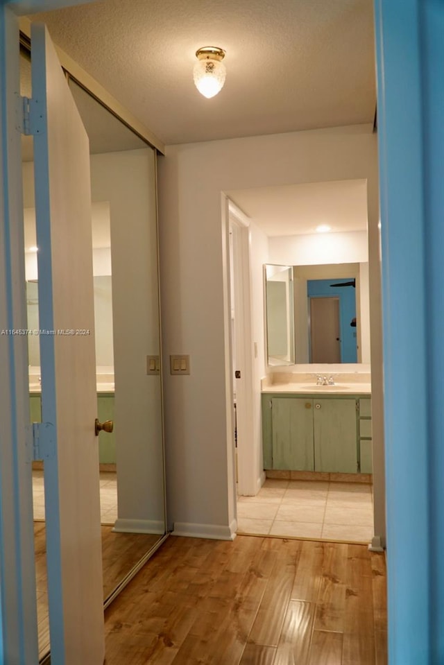 corridor featuring light wood-type flooring and sink