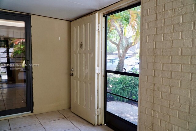 tiled entrance foyer with a healthy amount of sunlight