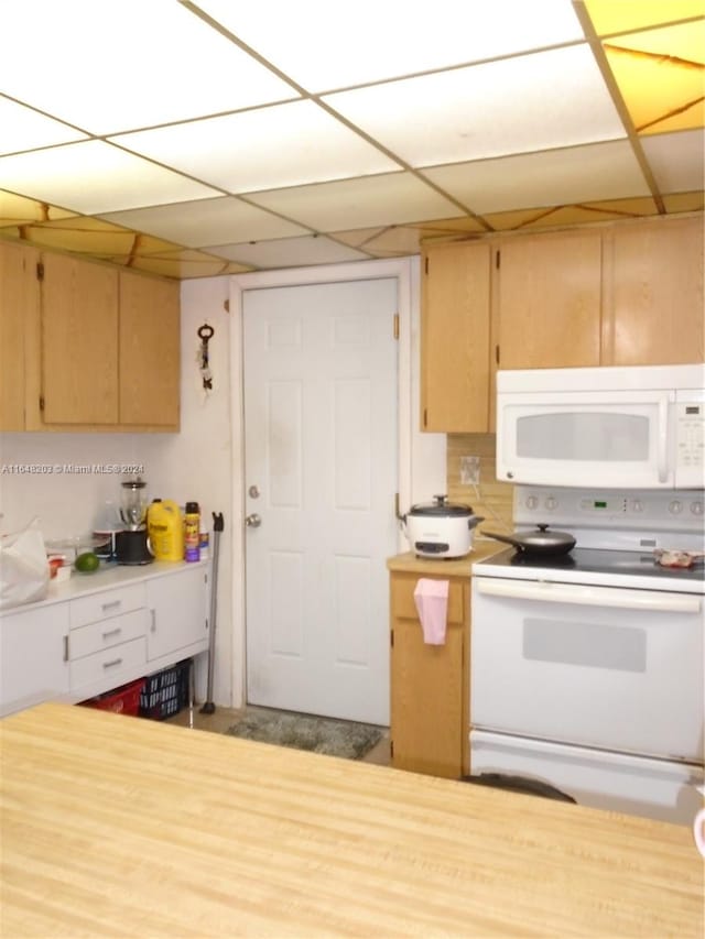 kitchen with white appliances and a paneled ceiling