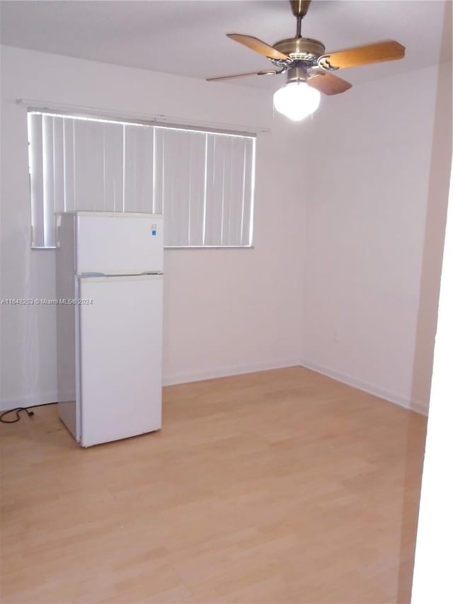 empty room with ceiling fan and light hardwood / wood-style floors