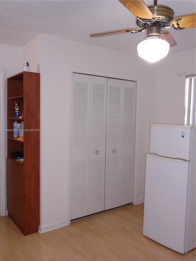 unfurnished bedroom featuring ceiling fan, white fridge, a closet, and light hardwood / wood-style flooring