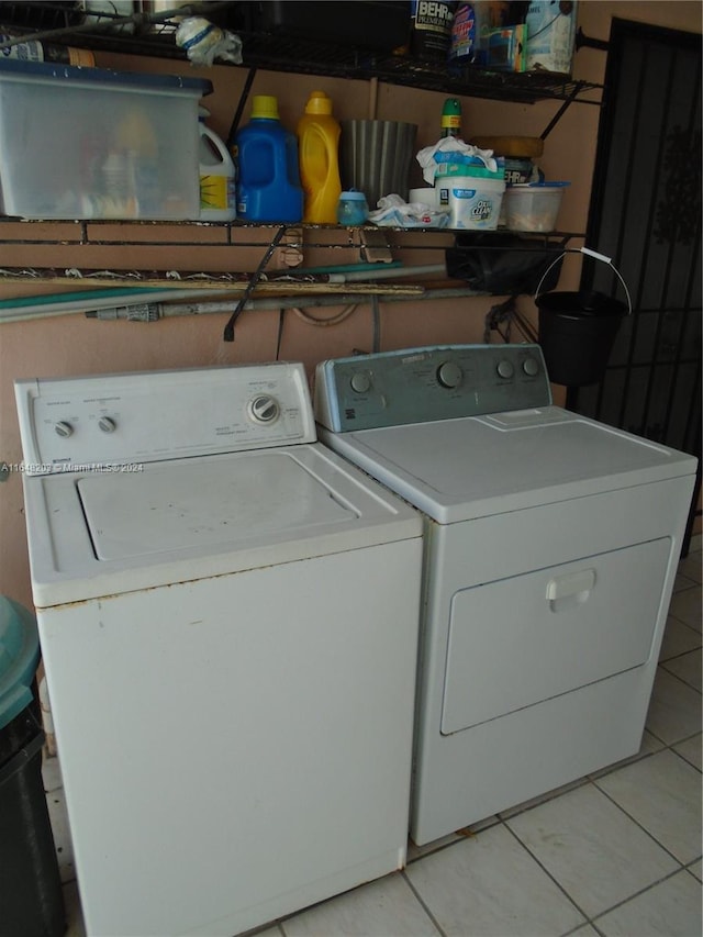 washroom with light tile patterned floors and washing machine and dryer