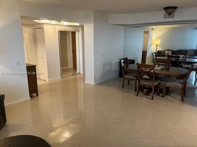 dining space featuring light tile patterned flooring and baseboards