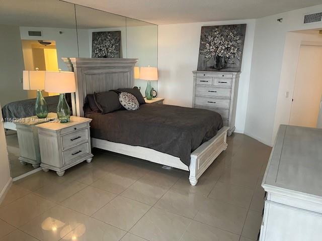 bedroom with visible vents and light tile patterned floors