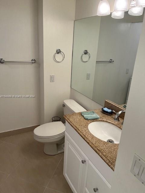 bathroom with vanity, toilet, and tile patterned floors