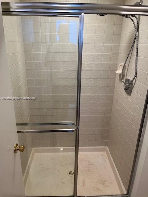 bathroom with a shower with door